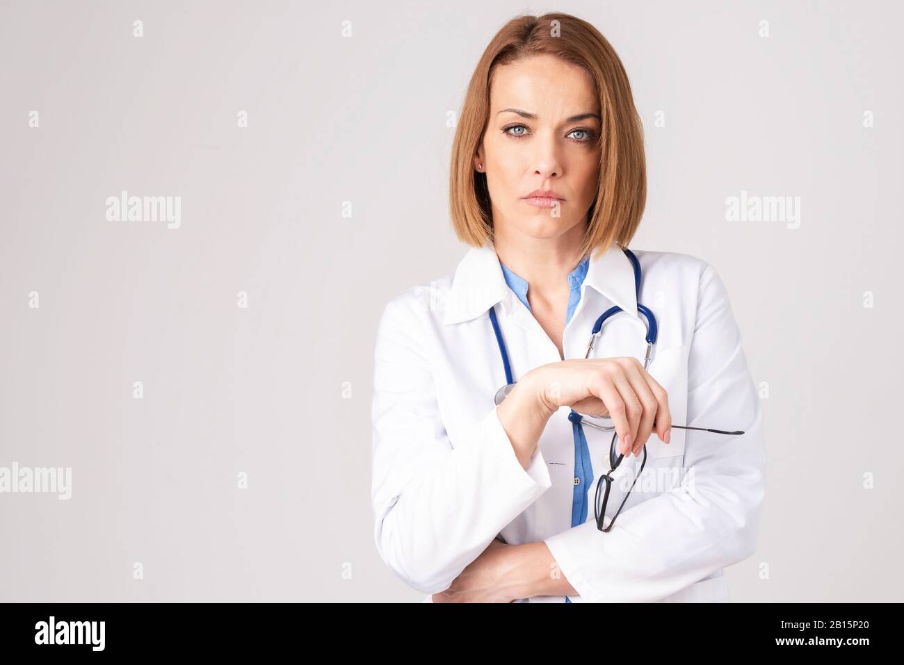 Porträtaufnahme einer Geschäftsfrau mittleren Alters, die formelle Kleidung trägt, während sie auf einem isolierten weißen Hintergrund steht. Stockfoto