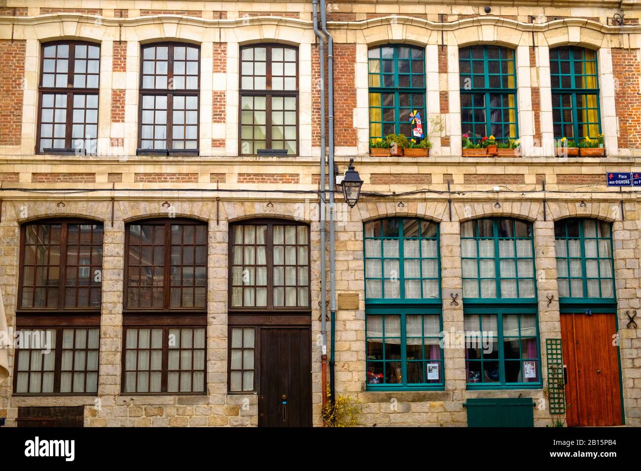 In der Altstadt von Lille stehen zwei symmetrische historische Häuser nebeneinander. Die hohen Fenster haben entweder grüne oder braune Muntine. Stockfoto