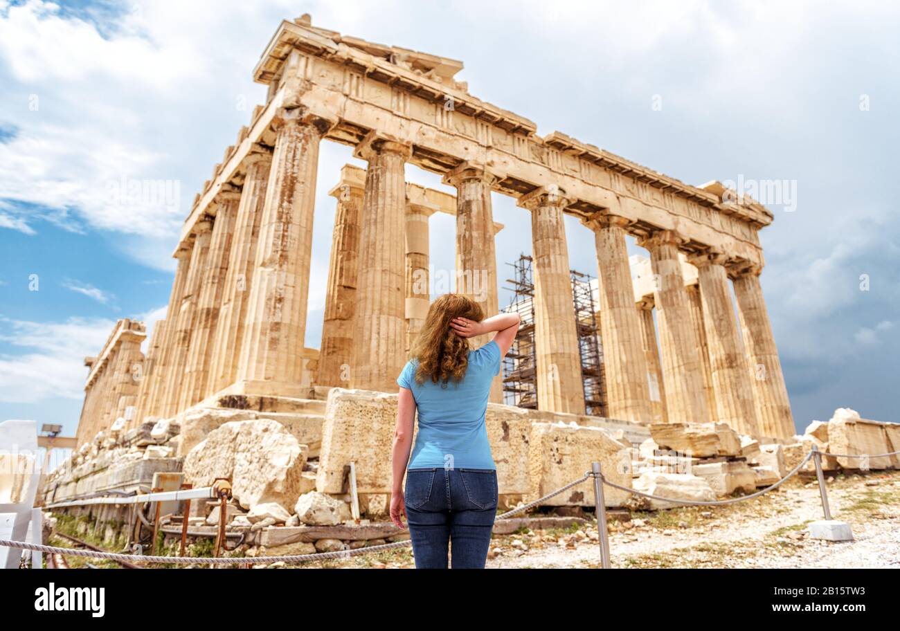 Junge Frau schaut auf der Akropolis von Athen, Griechenland, auf den Altgriechischen Parthenon. Dieser Ort ist eine der beliebtesten Touristenattraktionen Athens. Erwachsene Mädchen Reisende Stockfoto
