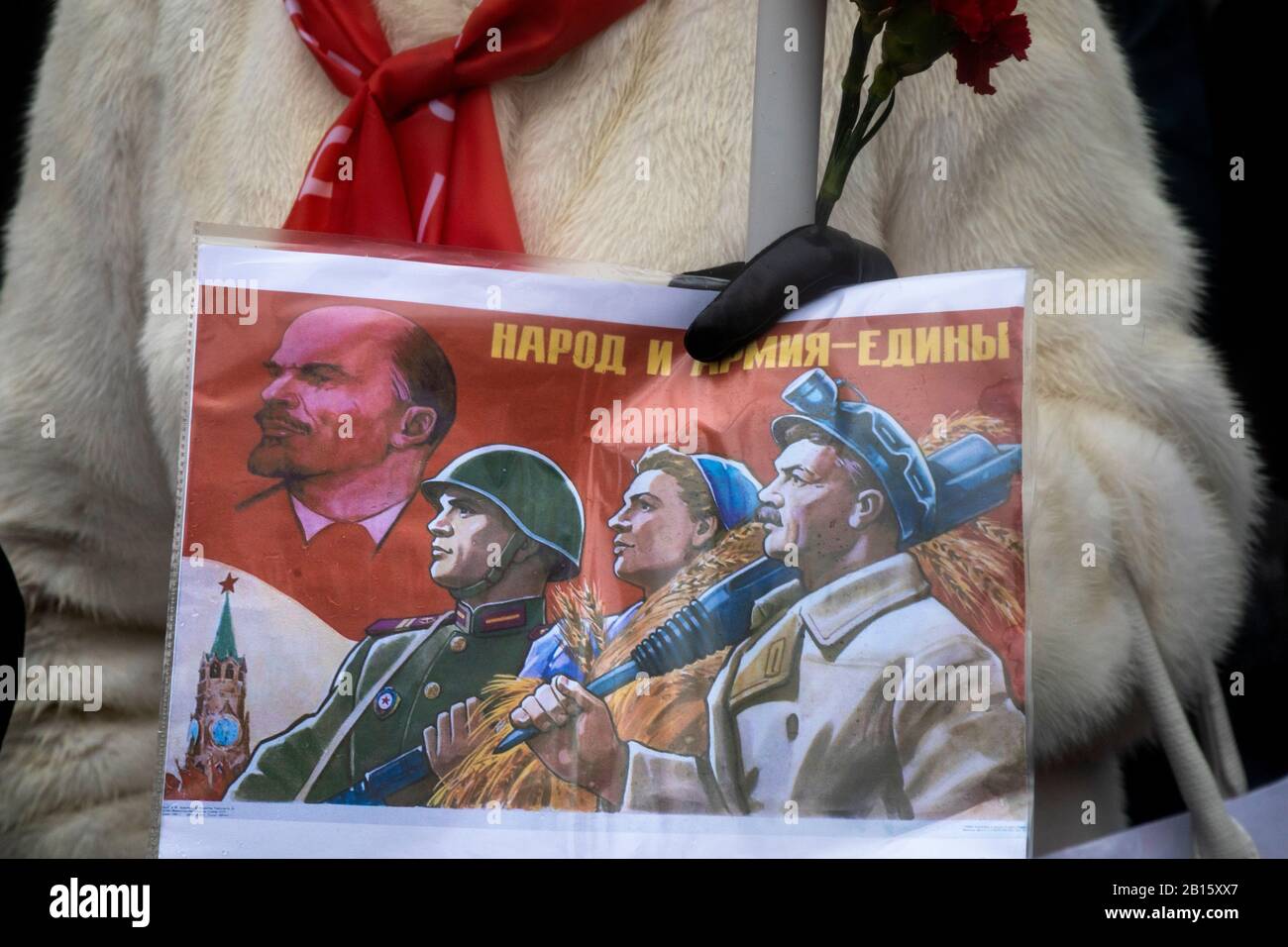 Moskau, Russland. Februar 2020 Teilnehmer einer Kundgebung und eines marsches in Zentral-Moskau anlässlich des 102. Jahrestages der Gründung der sowjetischen Roten Armee und der sowjetischen Marine. Eine Frau hält Plakat mit der sowjetischen Propaganda, die dem Tag der sowjetischen Armee gewidmet ist, mit der Aufschrift auf Russisch "Volk und Armee sind vereint" Stockfoto
