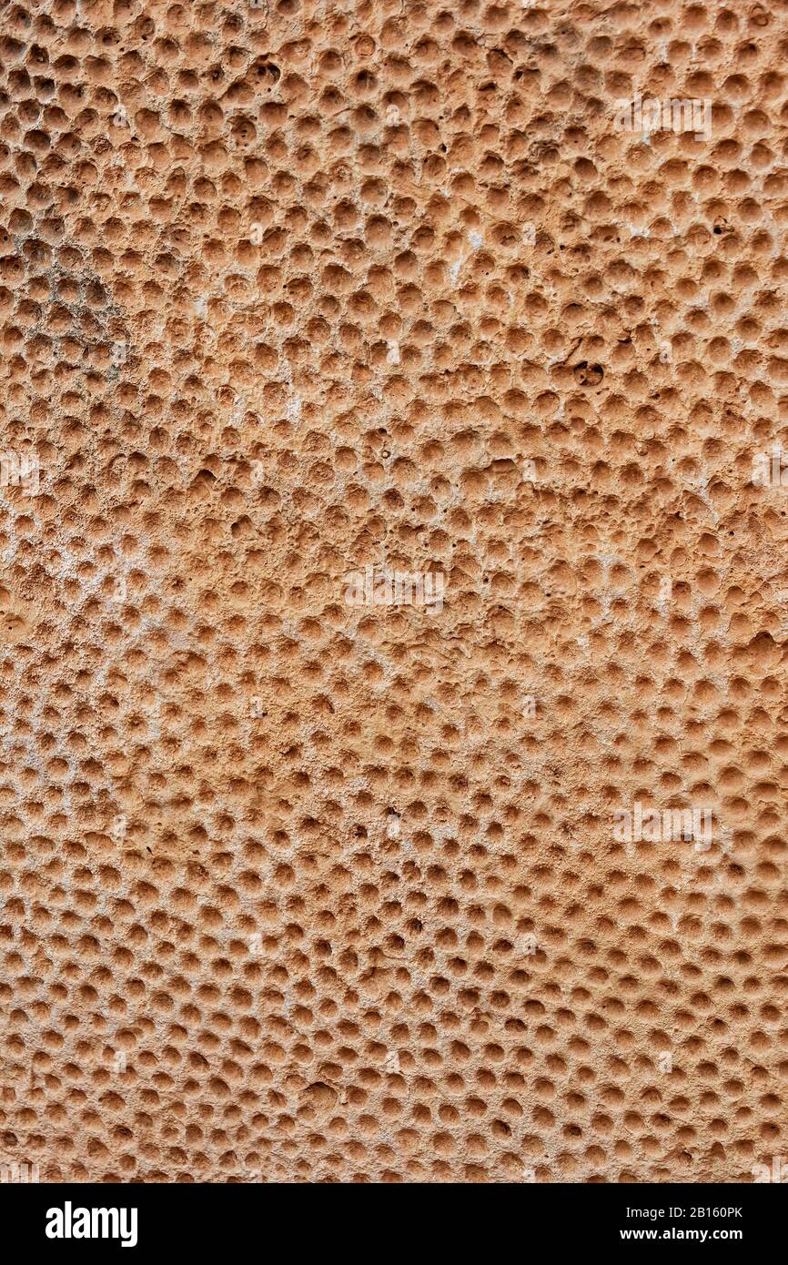 Verkleideter Megalith aus Kalksteinkalk mit gehauenen Tausenden von Löchern abstrakte Hintergrundtextur aus dem Megalithtempel Mnajdra auf Malta zwischen 3600 v. Chr. und 320 Stockfoto