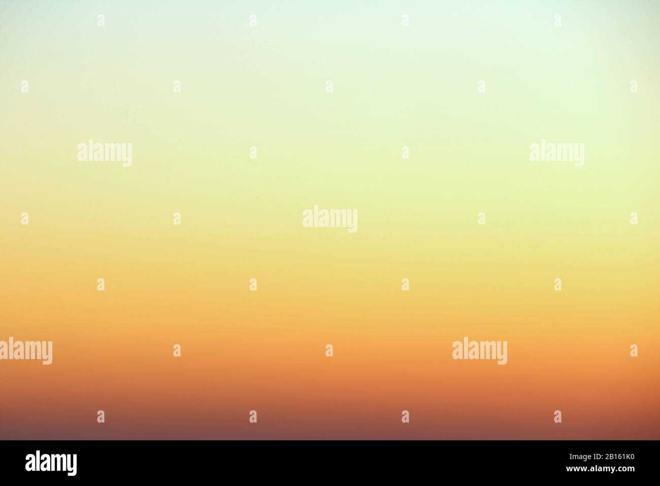 Flammender Himmel über dem Horizont bei Sonnenuntergang oder Sonnenaufgang. Leuchtend schillernde Farben von Gelb, Orange und Rot. Farbiger Hintergrund für Text und Design. Stockfoto