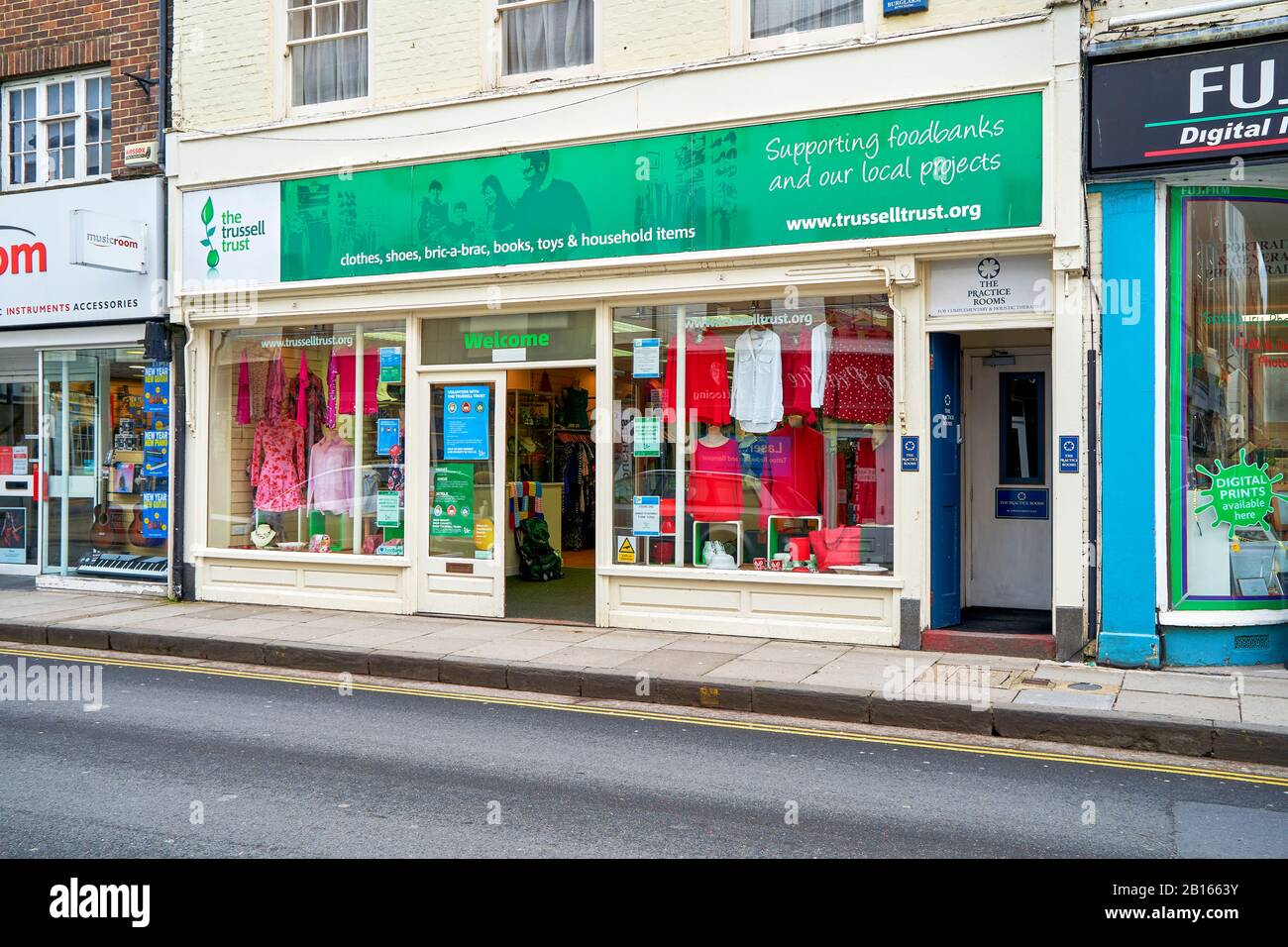 Trussell Trust Food-Bank-Charity-Shop mit gespendeter Kleidung in den Fenstern, die Eingangstür ist offen Stockfoto