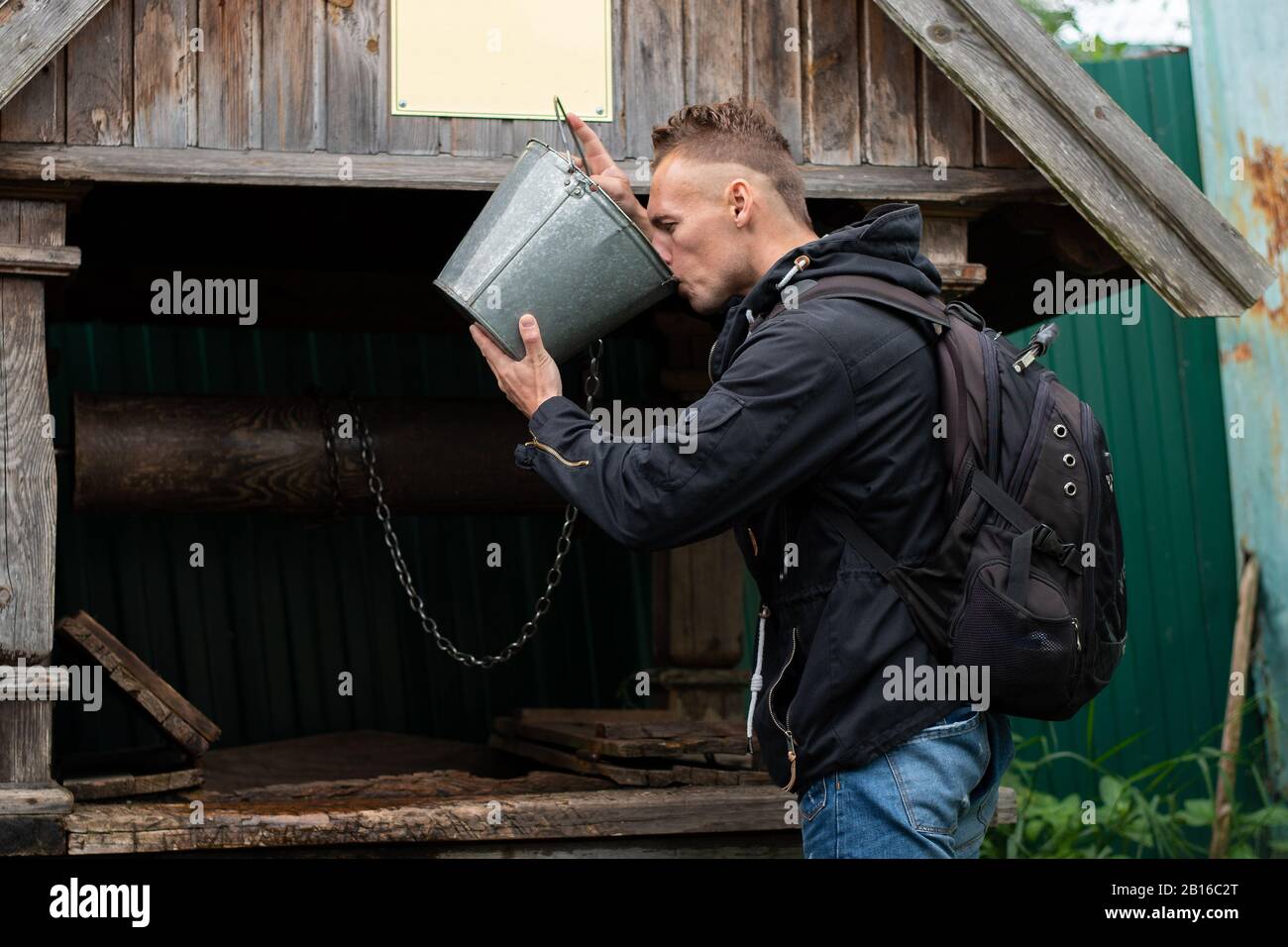 Mann trinkt aus Brunnen mit Wasser Stockfoto