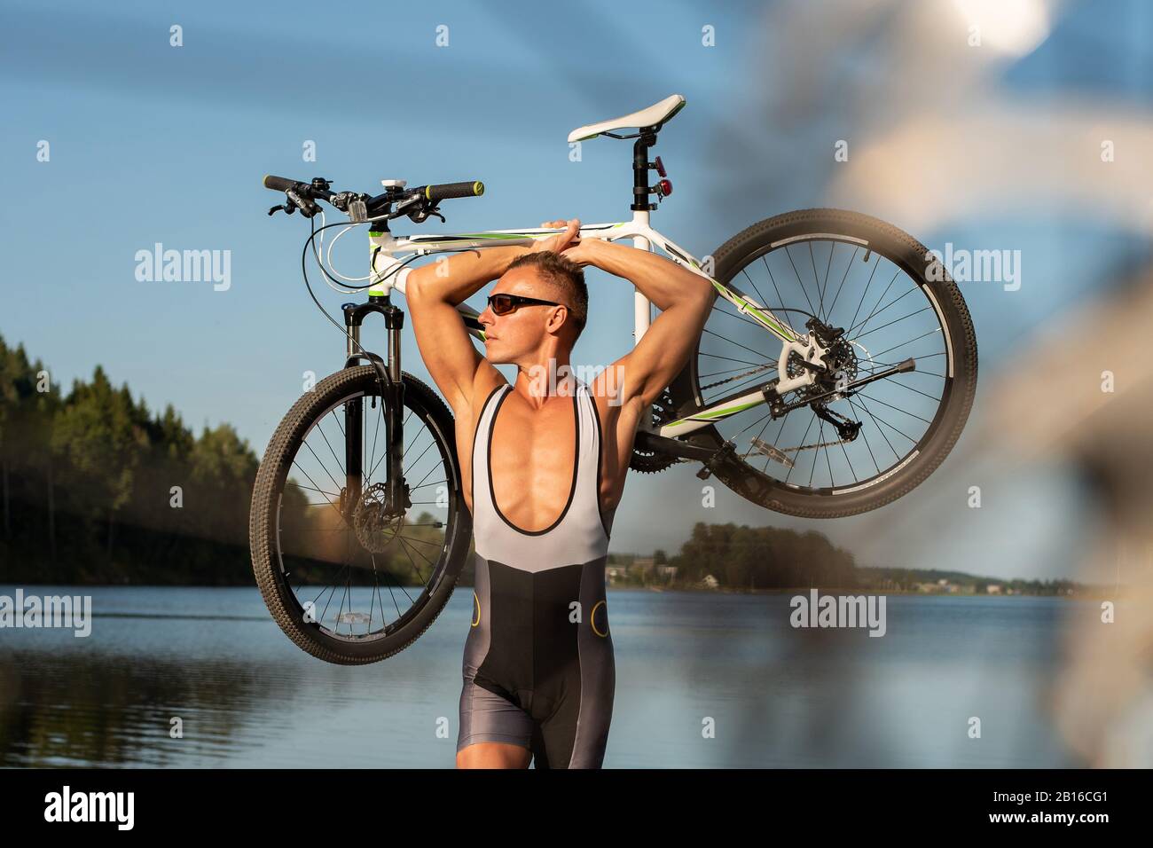 Ein Mann mit einem Fahrrad am Seeufer. Stockfoto