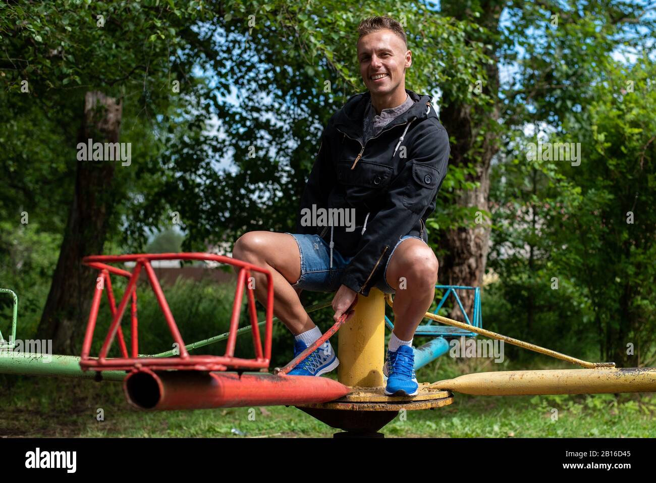 Ein Mann auf Babyschaukeln und Karussells. Stockfoto