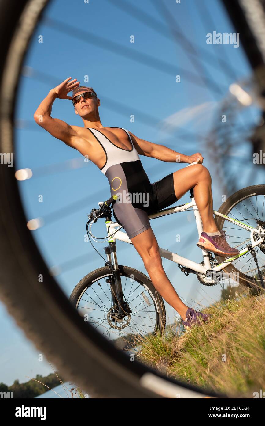 Ein Mann mit einem Fahrrad am Seeufer. Stockfoto
