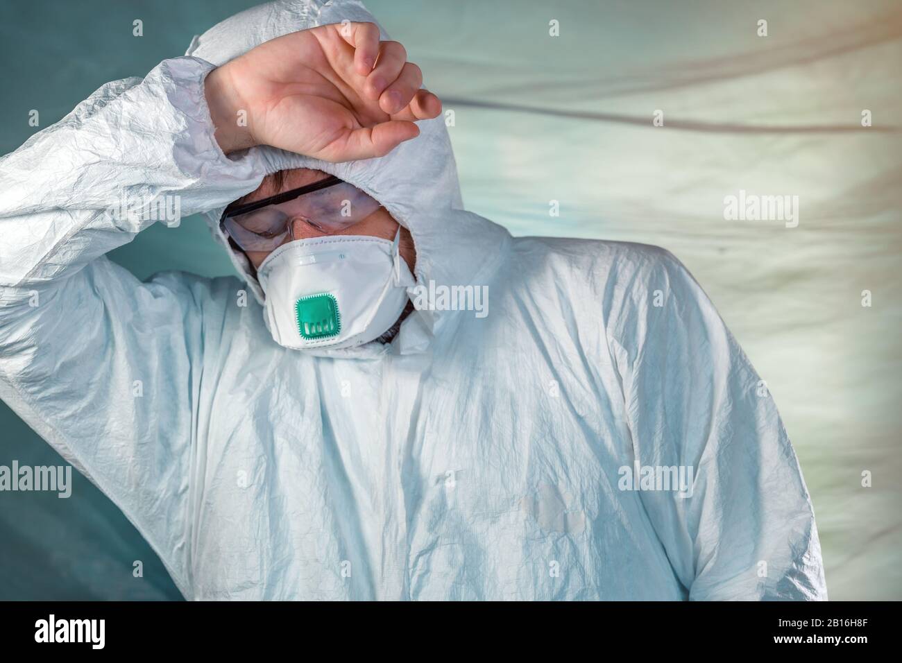 Müde Epidemiologen in wuhan-coronavirus Quarantäne, konzeptionelles Bild des medizinischen Facharztes, der Schutzkleidung und Maske trägt. Stockfoto