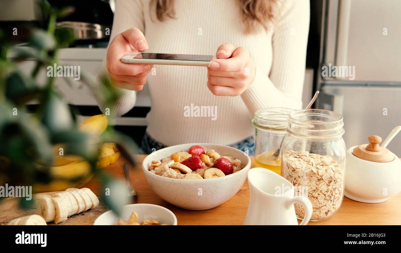 Blogger Mädchen Lebensmittelfotografie des Frühstücks in der Küche. Sonniger, fauler morgendlicher Lebensstil Stockfoto
