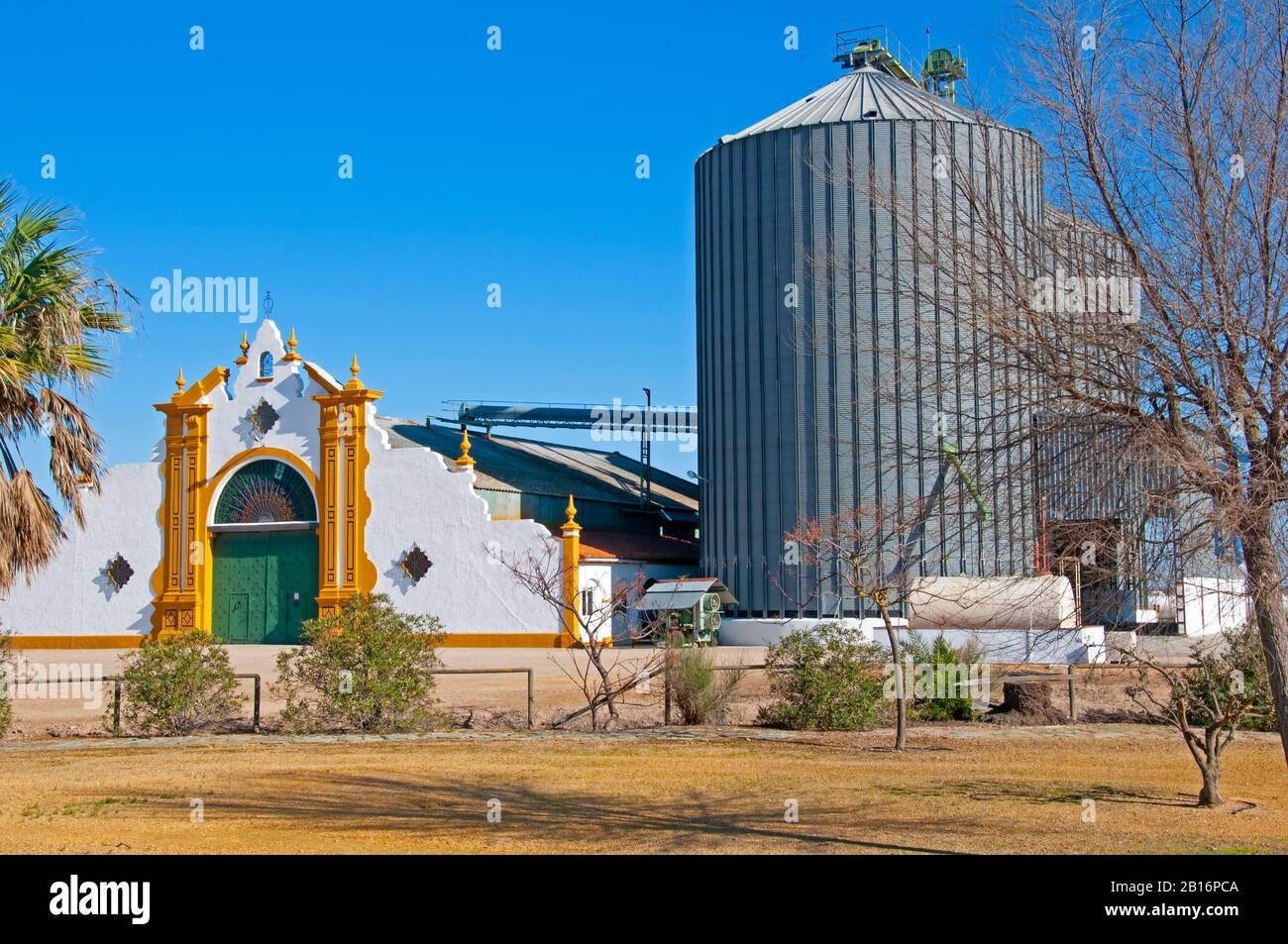 Schöner weißer Eingang zur Reisfabrik mit zwei großen Kornelevatoren, sonniger Herbsttag. Sevilla, Spanien Stockfoto
