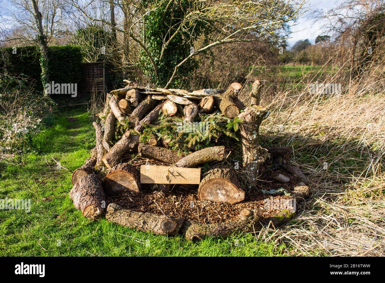 Bug Hotel. Eine Konstruktion aus Holzstämmen, Ästen und Holzhackschnitzeln, die von einem örtlichen Jugendclub angefertigt wurden, um in holt Wilts eine geeignete Umgebung für wilde Insekten zu bieten Stockfoto