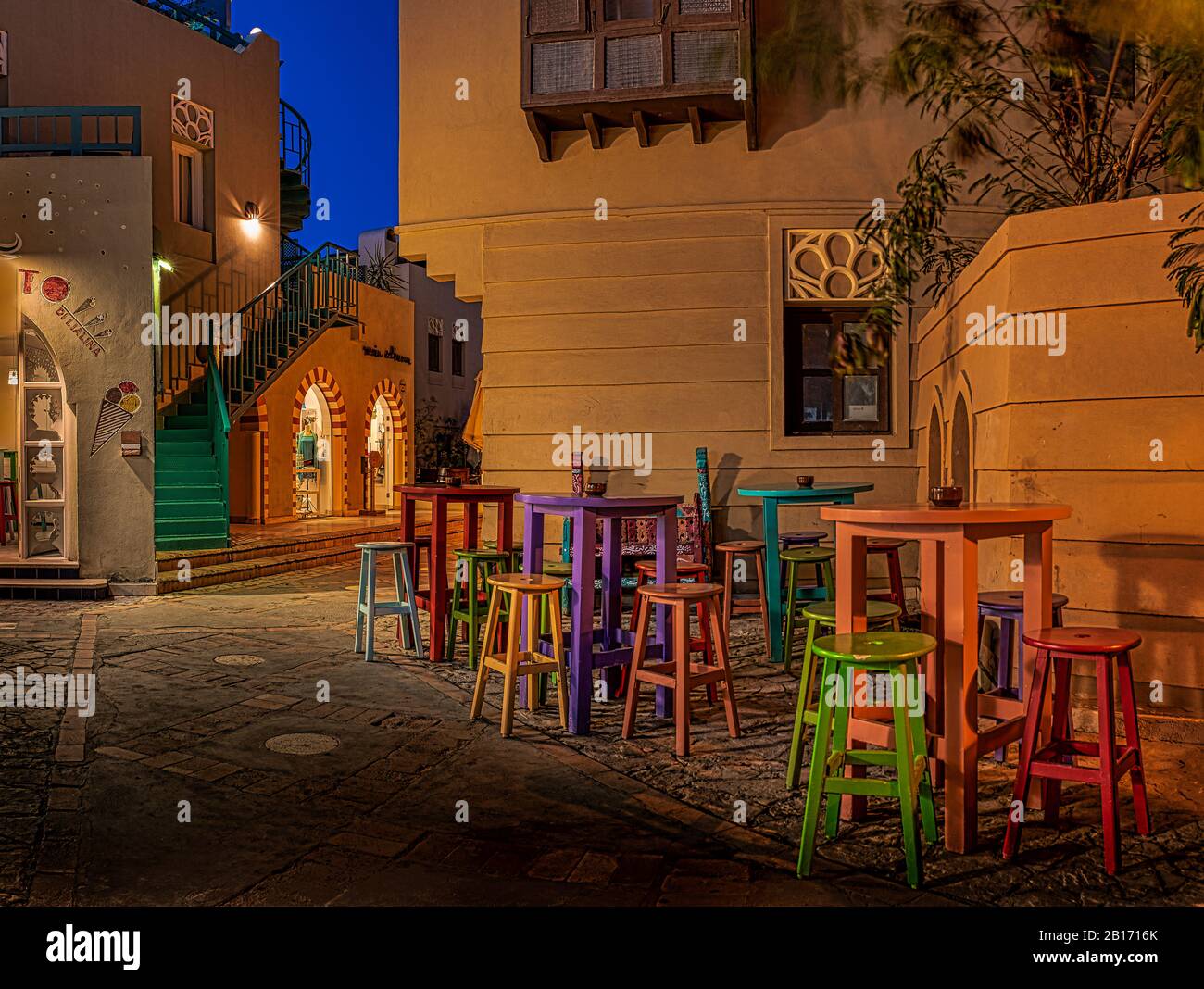 Kaffeebar mit bunten Tischen und Stühlen, nachts auf einem kleinen Platz in der Stadt el Gouna, Ägypten, 17. Januar 2020 beleuchtet Stockfoto