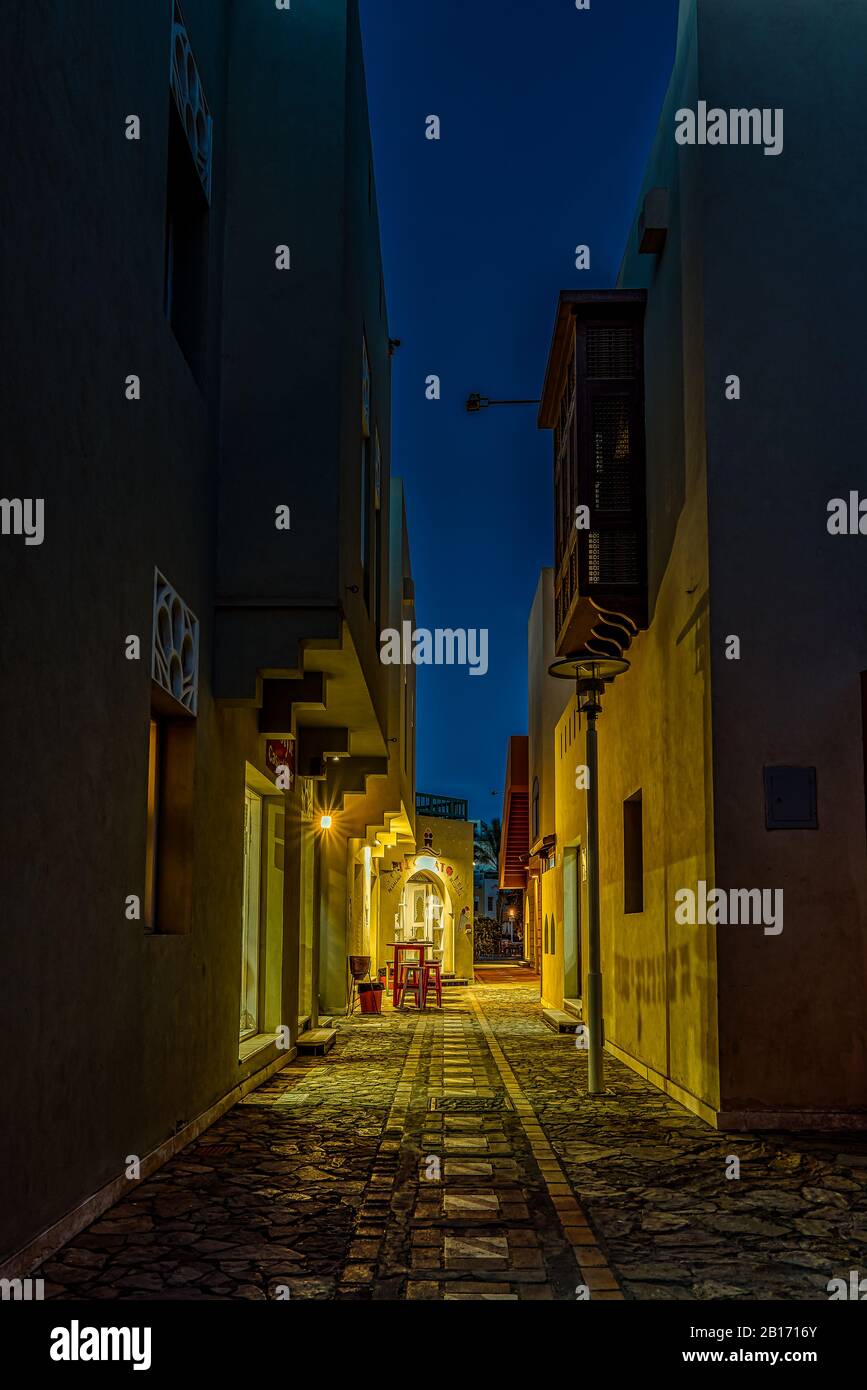 Eine enge Gasse in der Nacht mit beleuchteten Geschäften und dunklem Platz für Kopien, el Gouna, Ägypten, 17. Januar 2020 Stockfoto