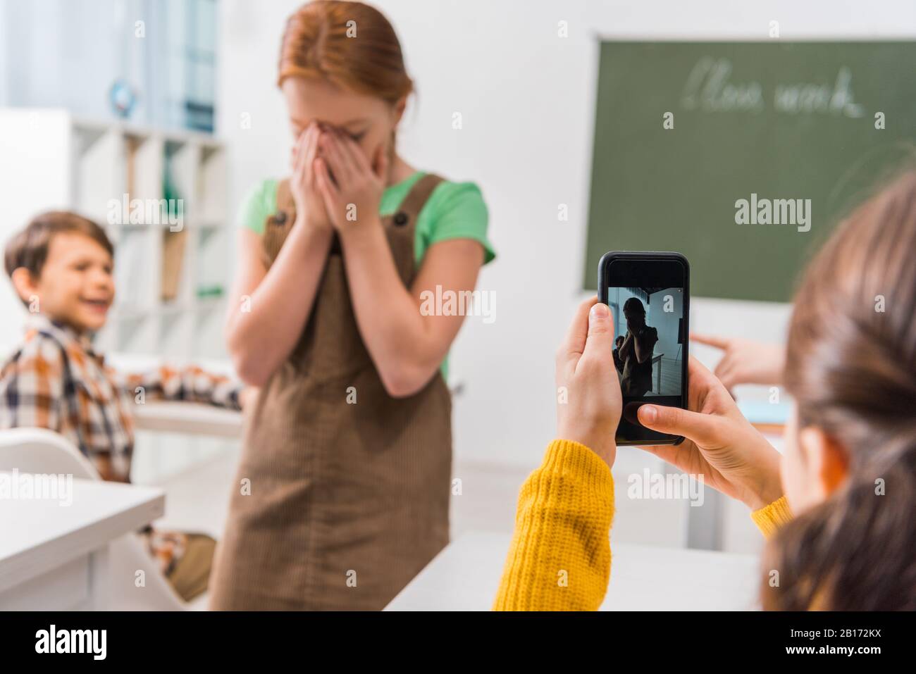 Selektive Fokussierung von Schulmädchen Foto von Mitschüler, Cyberbullying Konzept Stockfoto