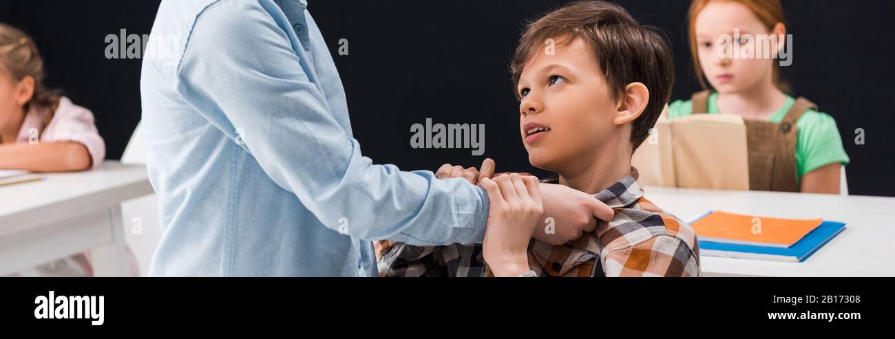 Panoramaaufnahme von Schulkindschikanen in der Nähe von Schulmädchen Stockfoto