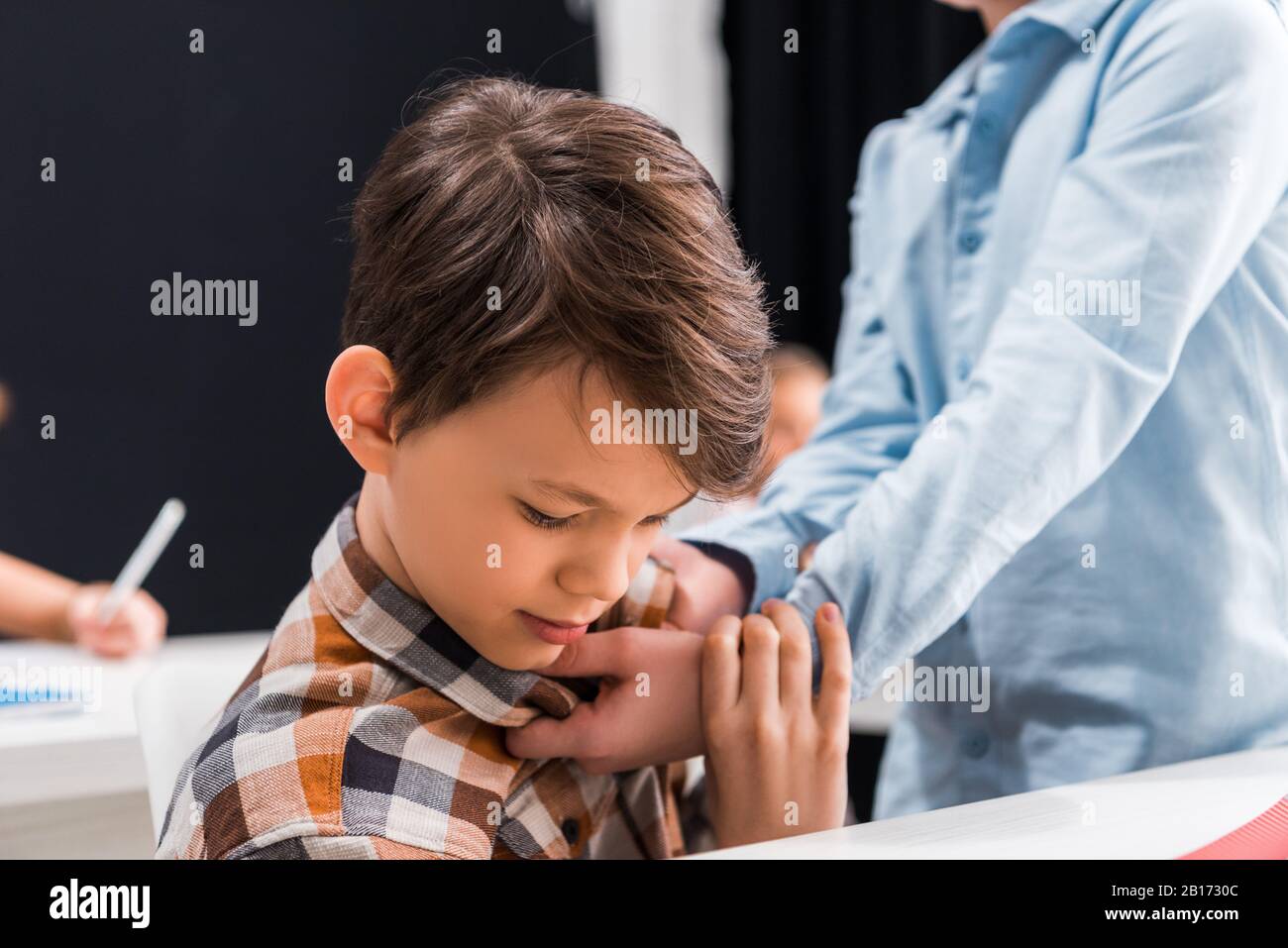 Selektive Fokussierung auf grausame Schulkindschikanen erschreckt Klassenkameraden Stockfoto
