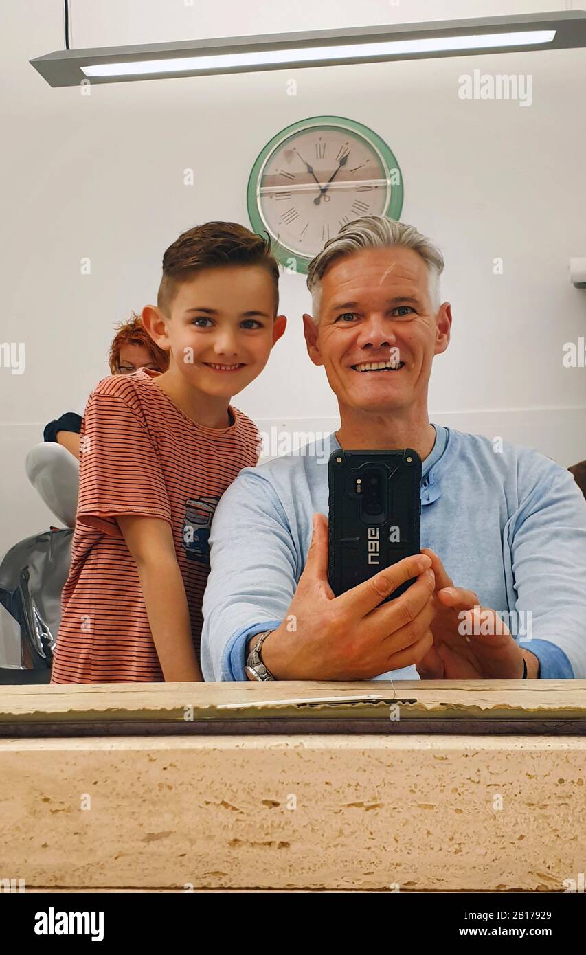 Vater und Sonne im Barbershop mit dem gleichen Haarstil, Deutschland Stockfoto