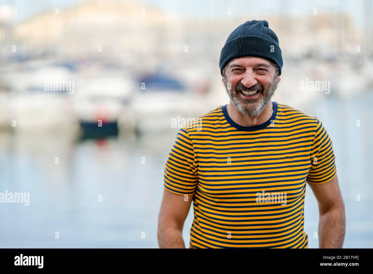 Portrait des lachenden reifen Mannes mit Mütze und gestreiftem T-Shirt, Alicante, Spanien Stockfoto