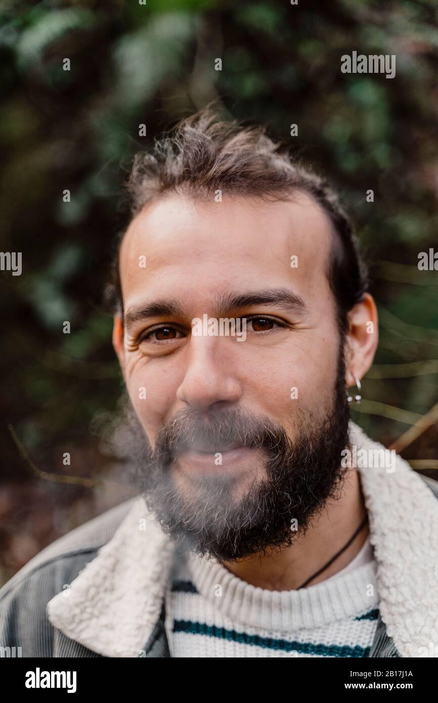 Porträt des jungen Mannes, Rauchen im Freien Stockfoto
