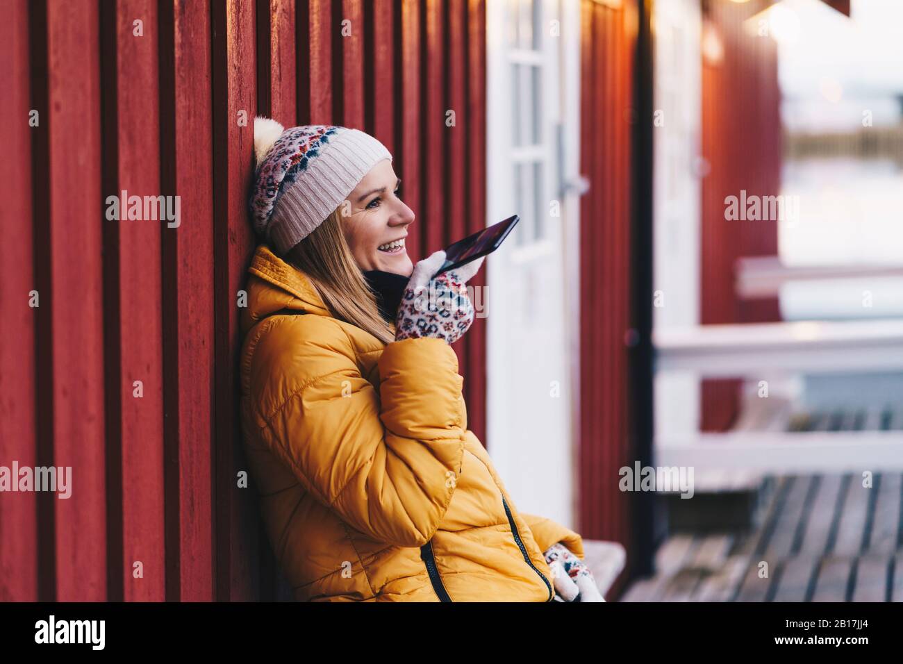 Fröhlicher Tourist mit Smartphone in Hamnoy, Lofoten, Norwegen Stockfoto