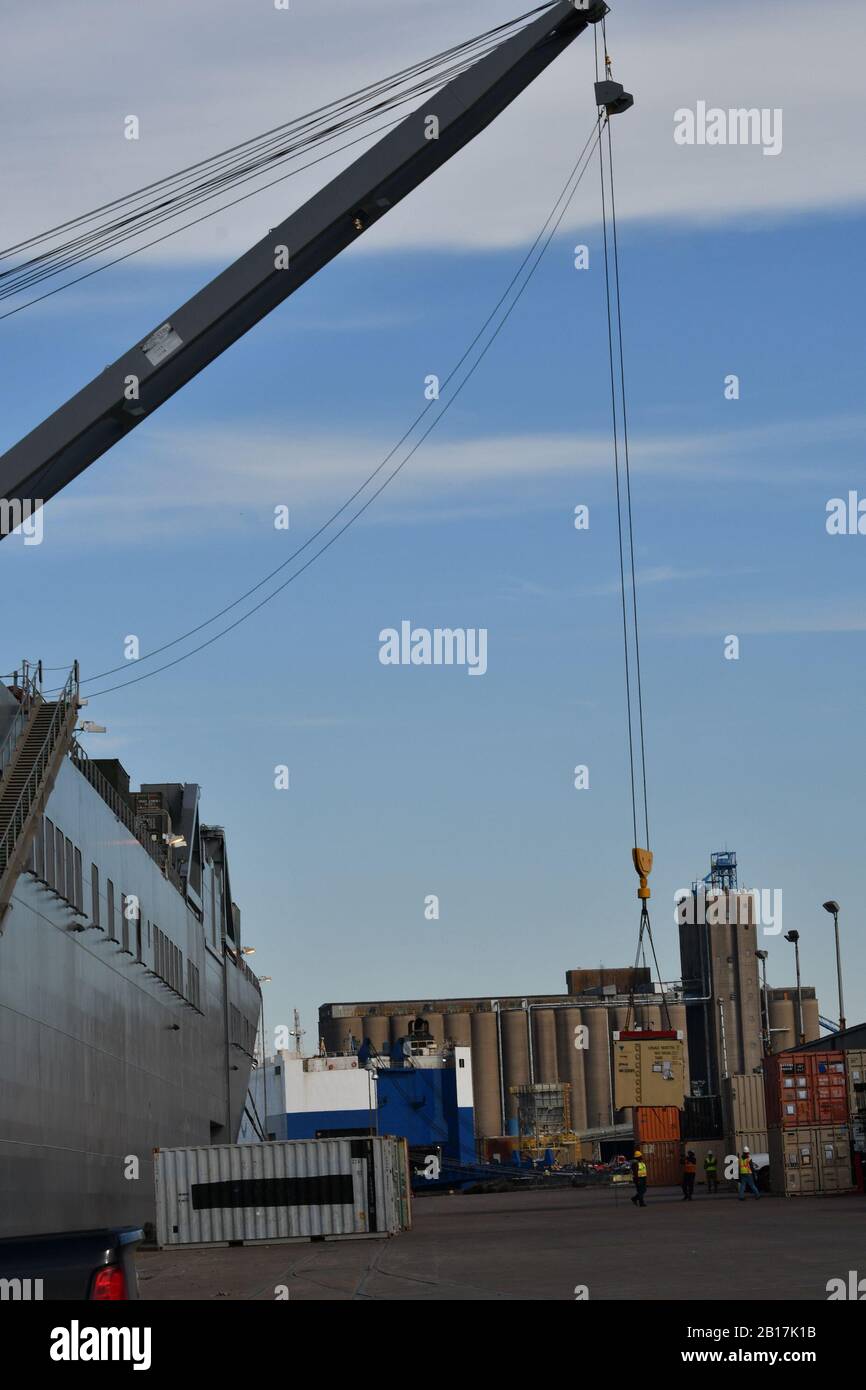 Mitglieder der Hubbande im Hafen von Beaumont, Texas führen gleichzeitig Auftrieb-/Abzugsoperationen auf dem Boden und Deck des Roll-On/Roll-Off-Schiffes der Bob Hope-Klasse USNS Benavidez am 22. Februar 2020 zur Unterstützung von DEFENDER-Europe 20 durch. Das Schiff wird militärische Ausrüstung als Teil von fast 6.000 Frachtstücken ins europäische Theater bringen, die das Militäroberflächeneinsatzkommando über Häfen im Golf von Mexiko verarbeiten wird. (USA Armeefoto.Kimberly Spinnner) Stockfoto