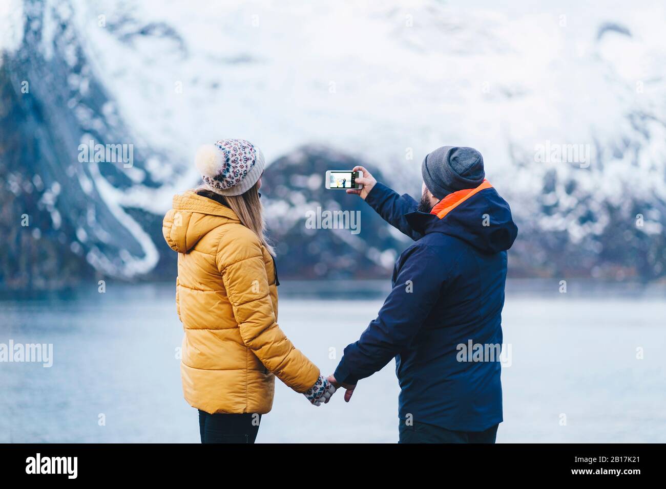 Tourist Paar, das ein Smartphone-Foto in Hamnoy, Lofoten, Norwegen gemacht hat Stockfoto