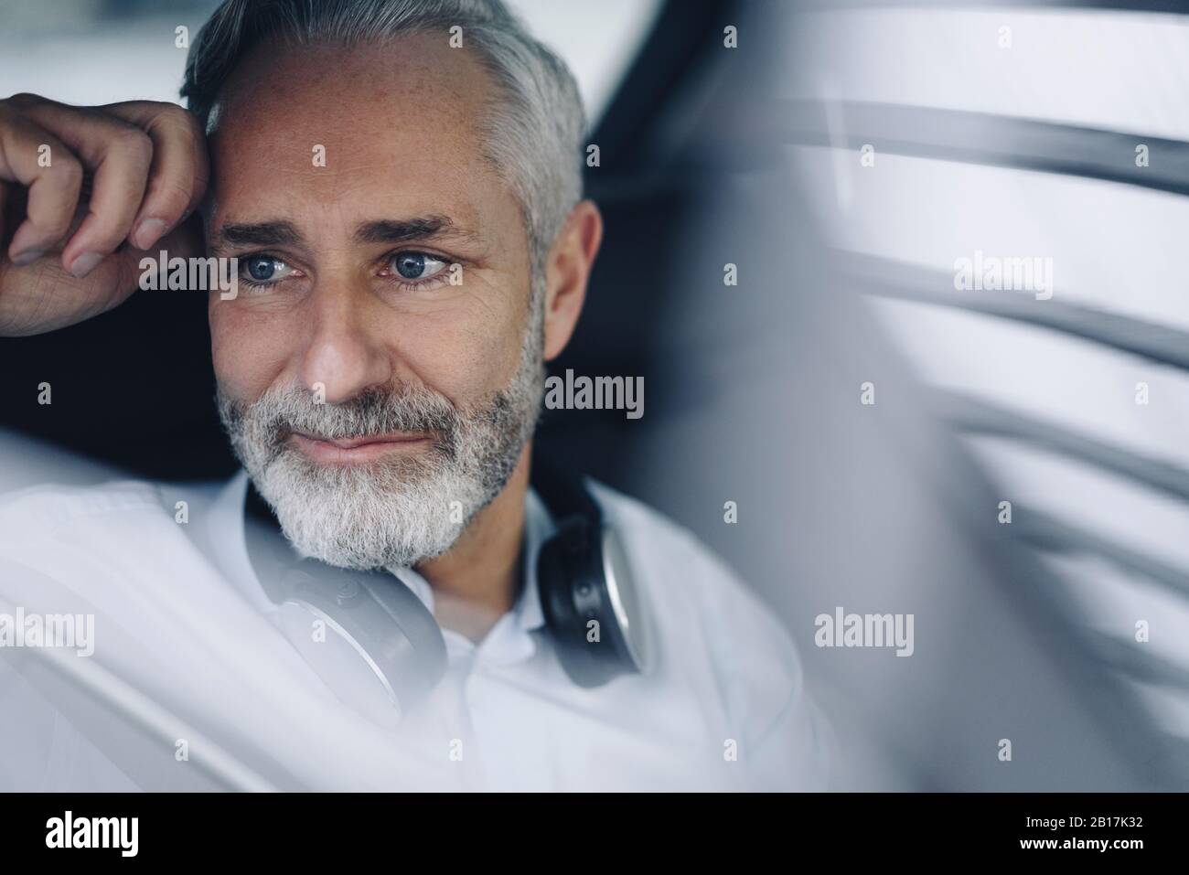 Porträt eines lächelnden reifen Geschäftsmannes in seinem Auto Stockfoto