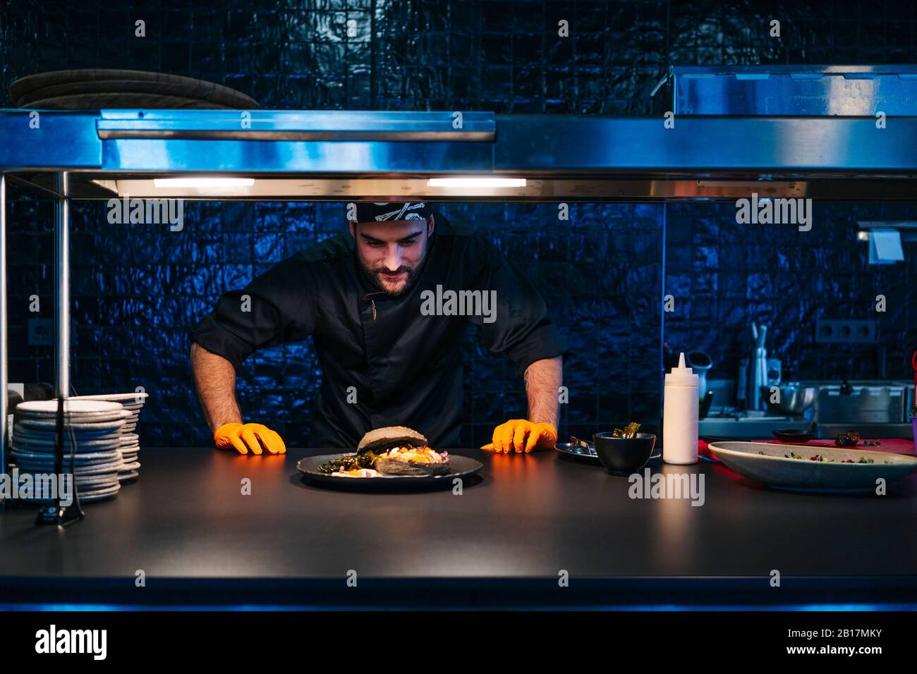 Koch schaut auf zubereitete Gericht in der Restaurantküche Stockfoto
