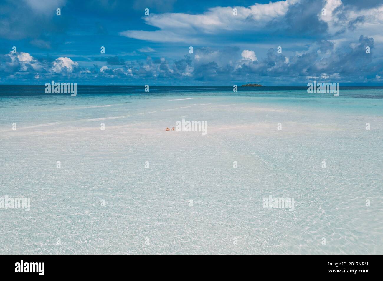 Frau, die auf einer Sandbank im Meer liegt, Maguhdhuvaa-Insel, Gaafu Dhaalu Atoll, Malediven Stockfoto