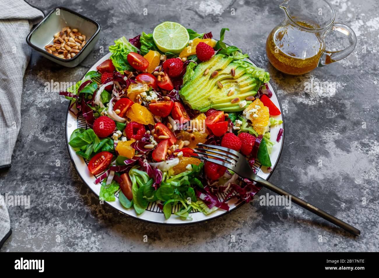 Studio Schuss fruchtiger Salatplatte mit Lämmer Salat, Radicchio, Salat Herzen, Avocado, Tomaten, Pinienkerne, Himbeeren, Orangen, Limette Stockfoto