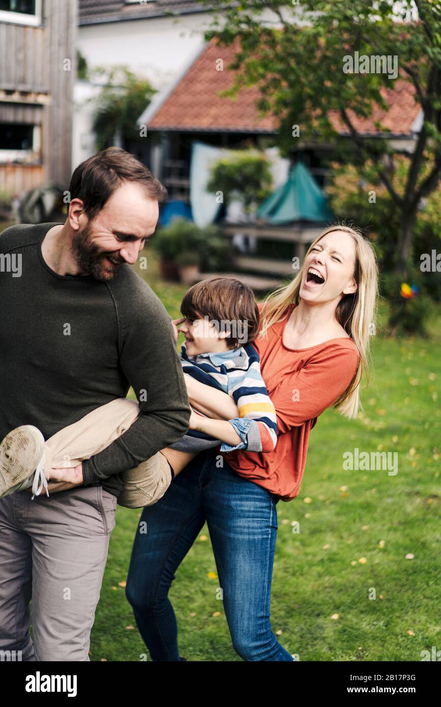 Eltern und Sohn haben Spaß und spielen im Garten Stockfoto