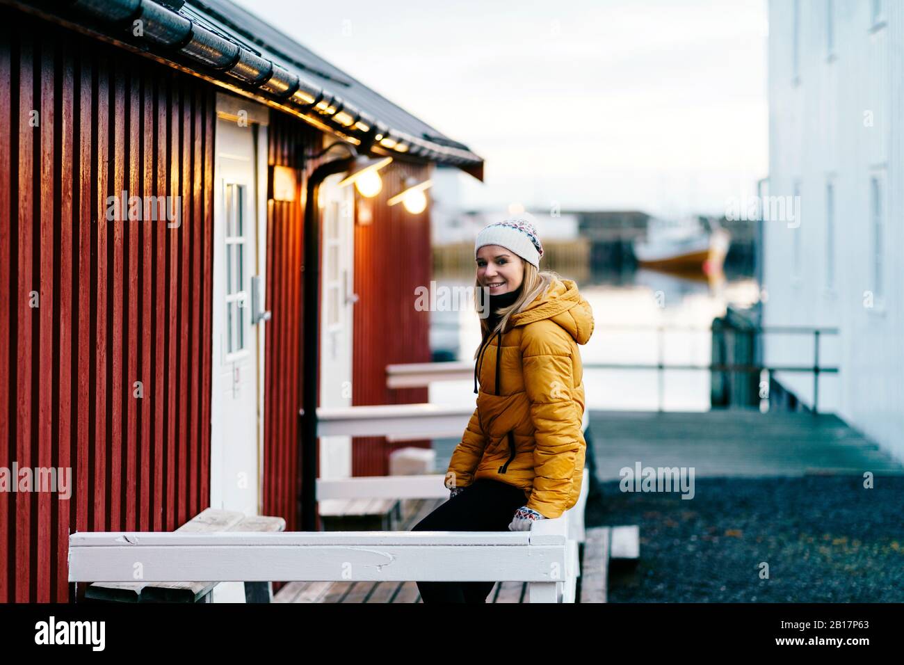 Porträt eines lächelnden Touristen auf einer Veranda in Hamnoy, Lofoten, Norwegen Stockfoto