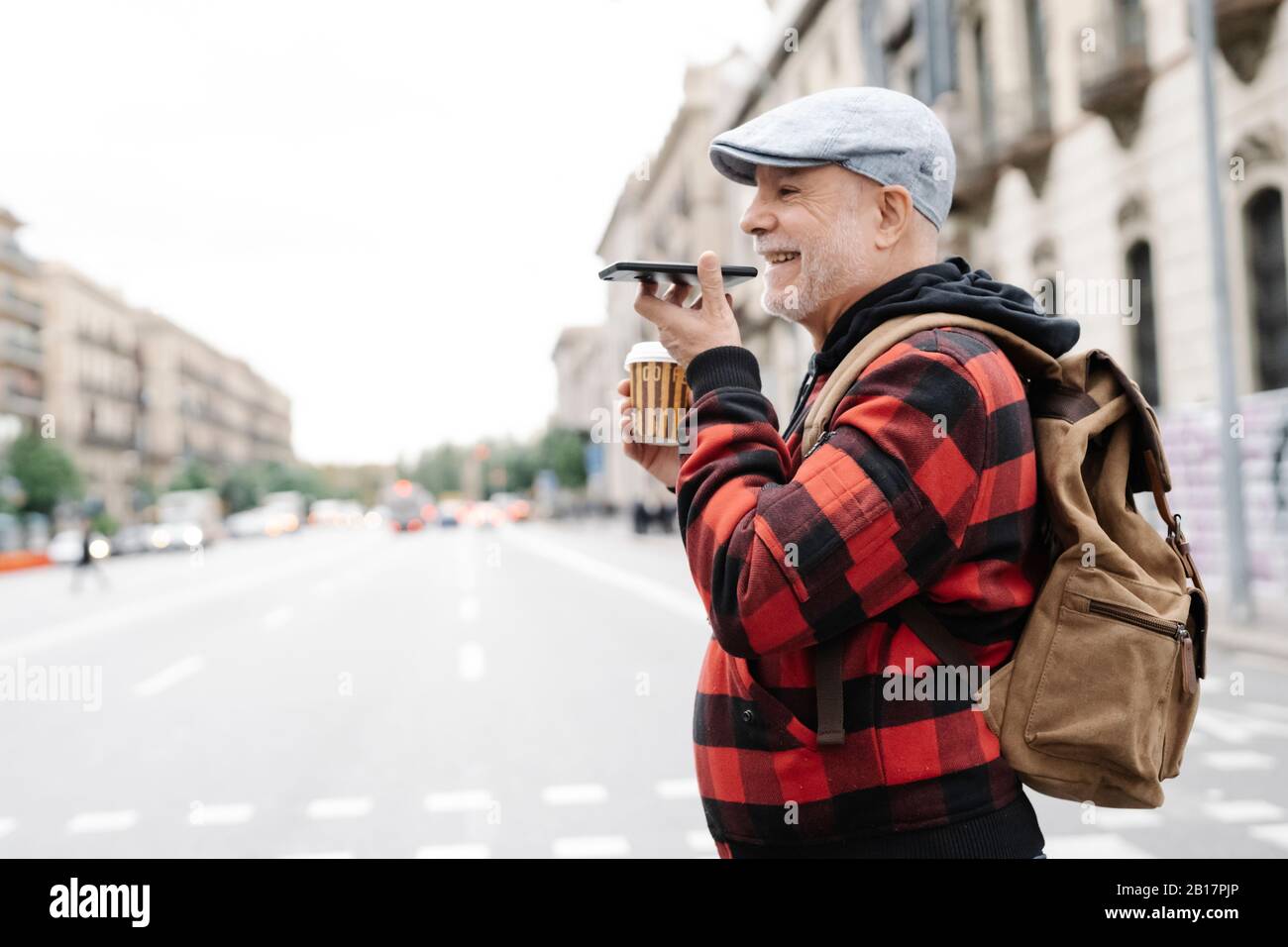 Älterer Mann am Telefon, der die Straße überquert, Barcelona, Spanien Stockfoto