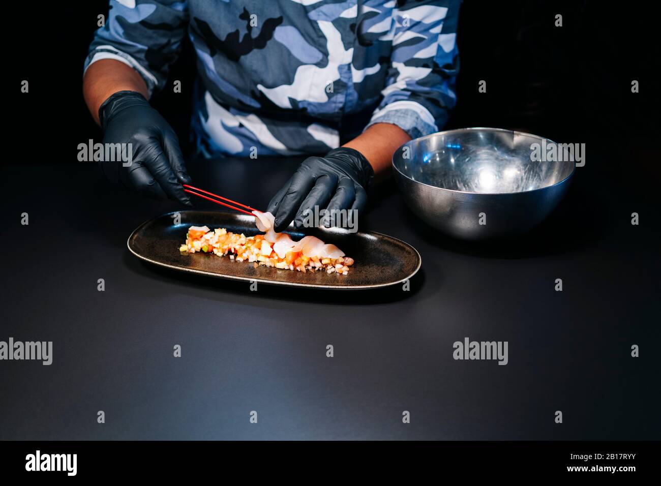 Nahaufnahme des Küchenchefs, der ein Gericht in der Restaurantküche zubereitet Stockfoto