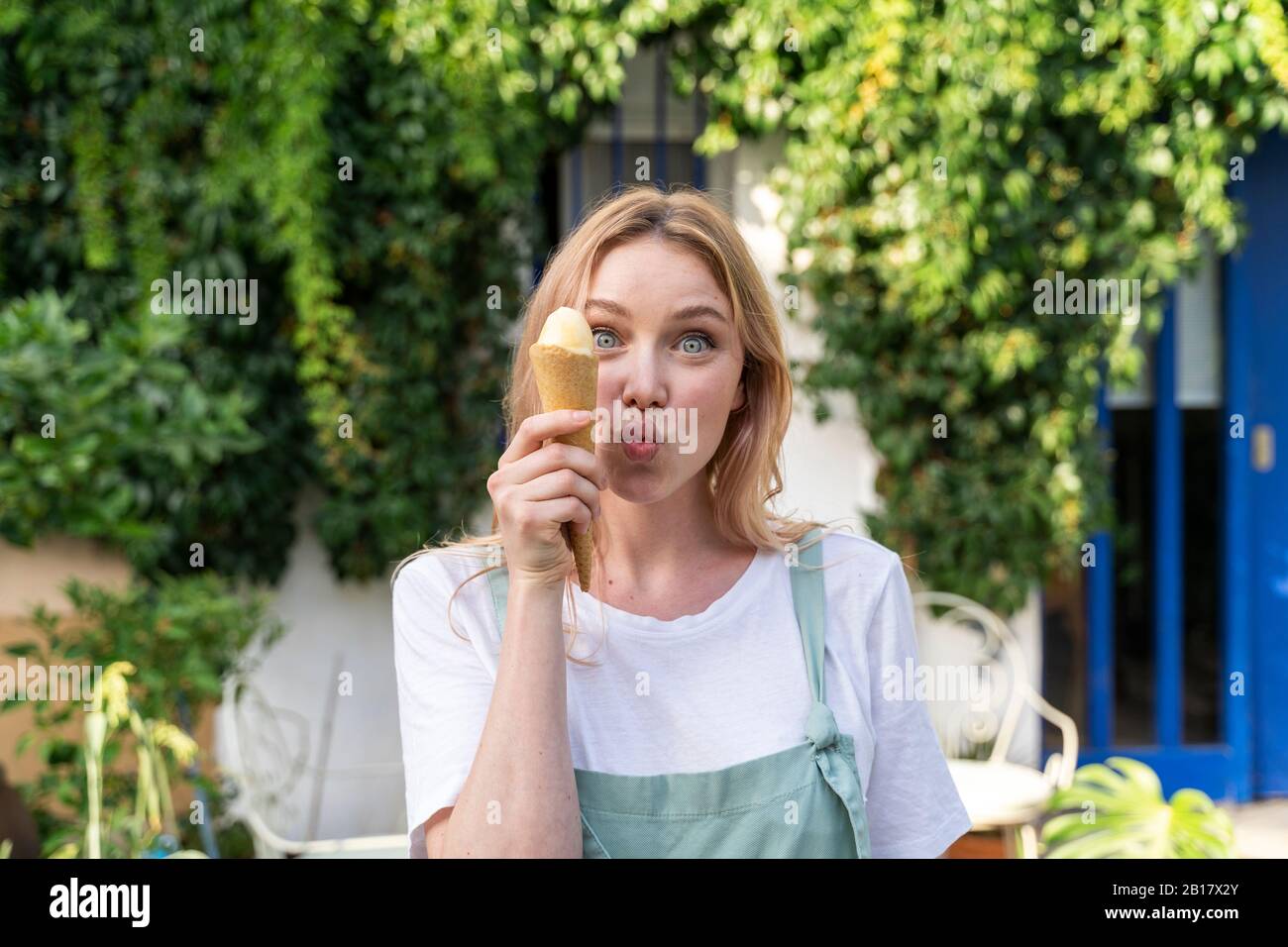 Porträt der jungen Frau mit Eiscreme Kegel ziehen lustige Gesichter Stockfoto