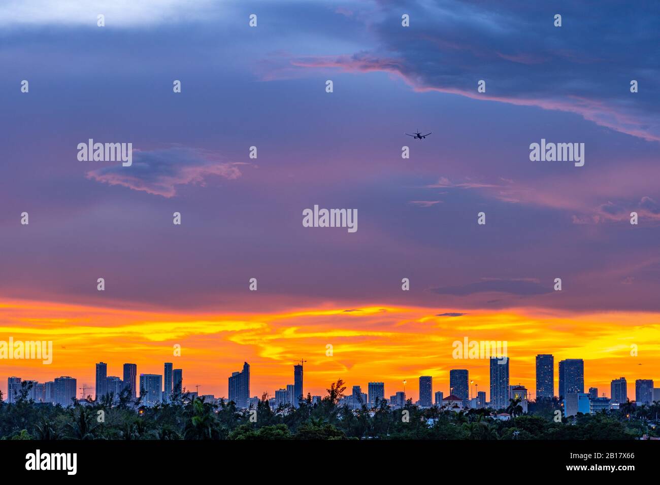 Flugzeug, das bei Sonnenuntergang über der Stadt Miami landet Stockfoto