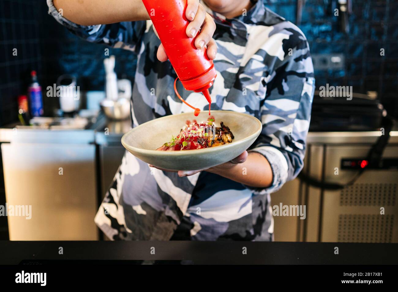 Küchenchef bereitet ein Gericht in der Restaurantküche zu Stockfoto