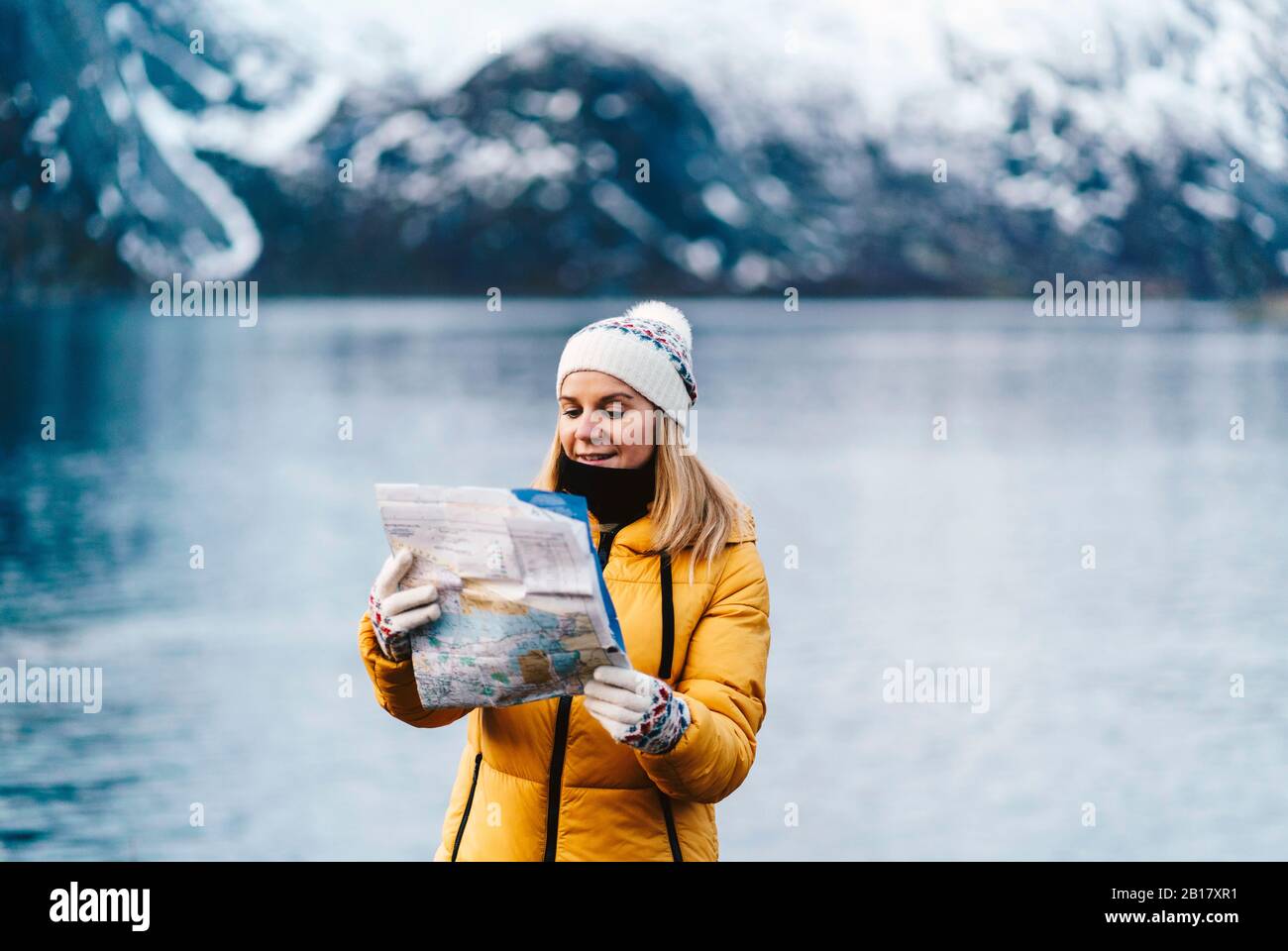 Touristen, die eine Karte an der Küste in Hamnoy, Lofoten, Norwegen lesen Stockfoto