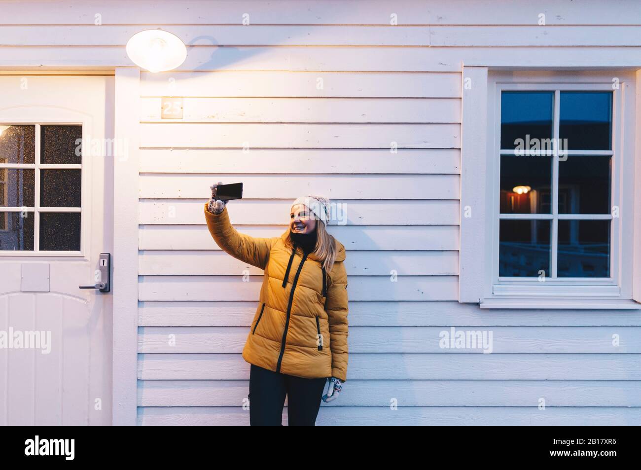 Tourist, der eine selfie in einer Hütte in Hamnoy, Lofoten, Norwegen, nimmt Stockfoto