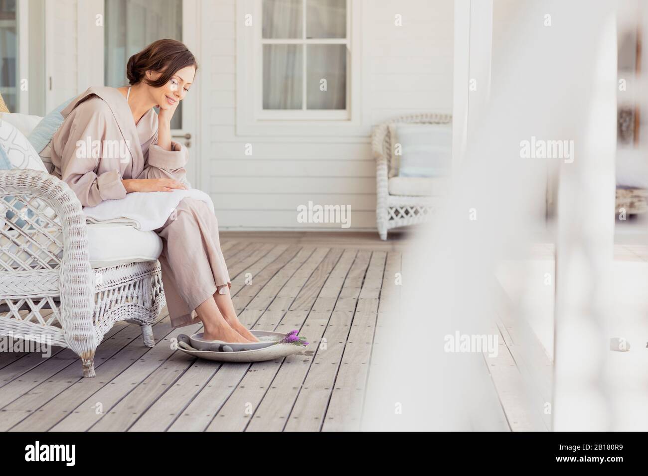 Frau mit einem Fußbad auf einer Veranda Stockfoto