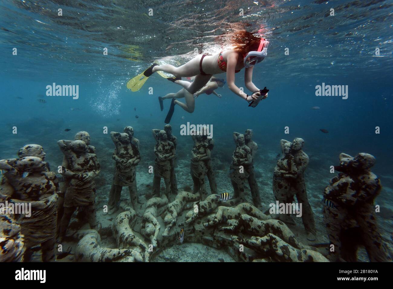 Frauen schwimmen in der Nähe von Unterwasser-Skulpturen von Jason deCaires Taylor, Gili Meno Insel, Bali, Indonesien Stockfoto