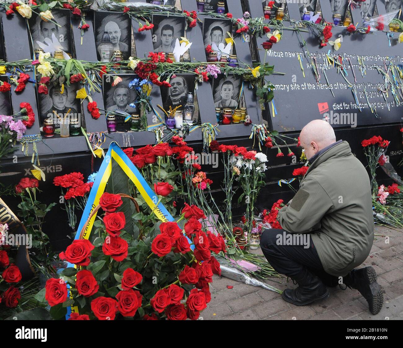 Kiew, Ukraine. Februar 2020. Ein Mann gibt Blumen in Erinnerung an die Euro-Maidan-Aktivisten oder "Helden der himmlischen Hundert", die während der Anti-Regierungs-Proteste 2014 im Zentrum von Kiew getötet wurden.die Ukrainer markieren den 6. Jahrestag der Maidan-Revolution oder Euromaidan-Revolution, bei der mindestens 100 Demonstranten getötet wurden. Credit: Sopa Images Limited/Alamy Live News Stockfoto