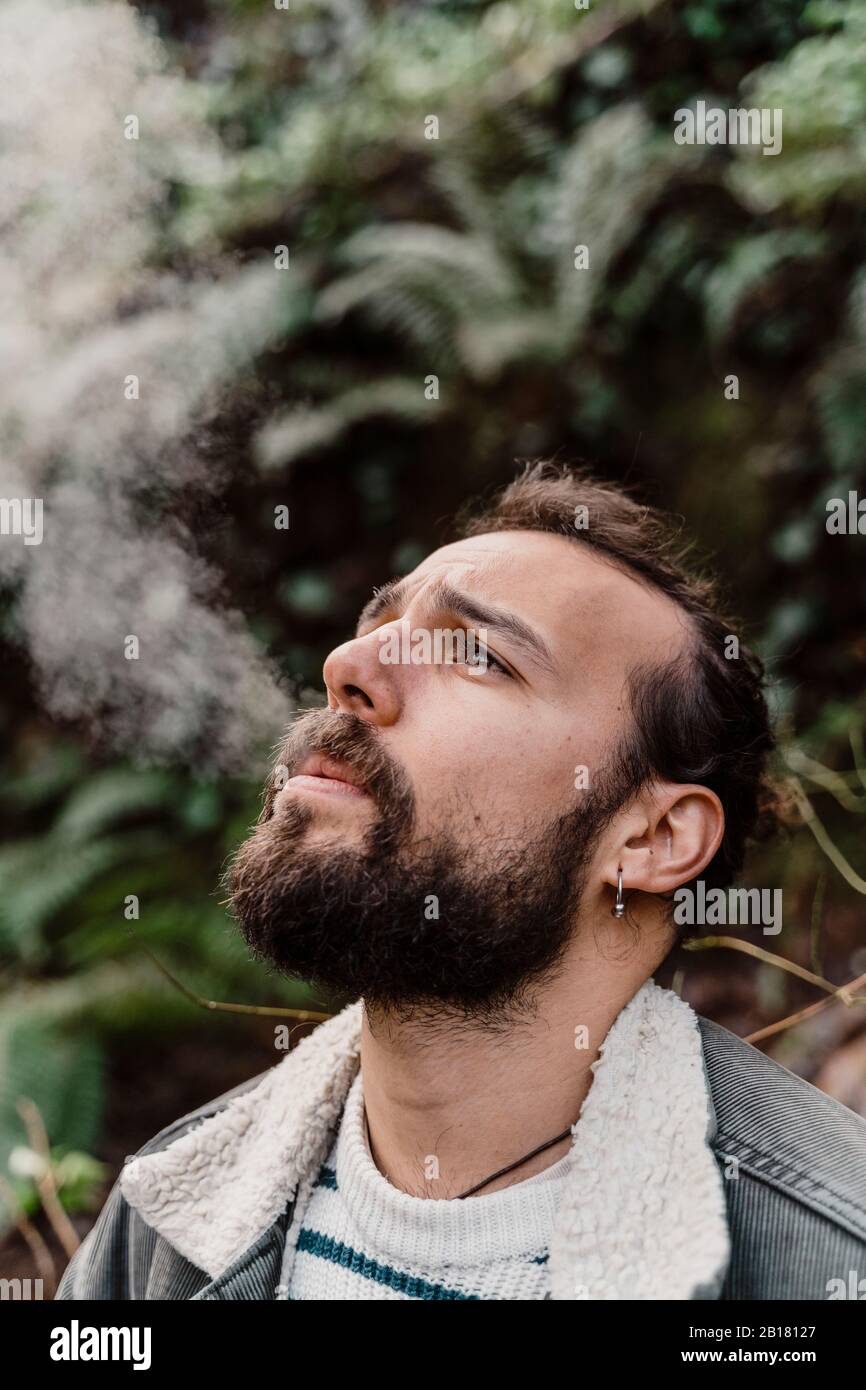 Porträt des jungen Mannes, Rauchen im Freien Stockfoto