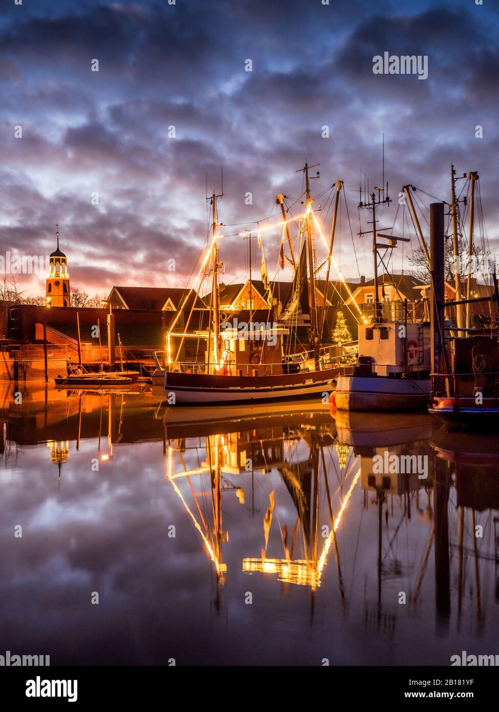 Deutschland, Niedersachsen, Landkreis leer, Friesland, Ditzum, Schiff beleuchtet für Weihnachten in der Dämmerung Stockfoto