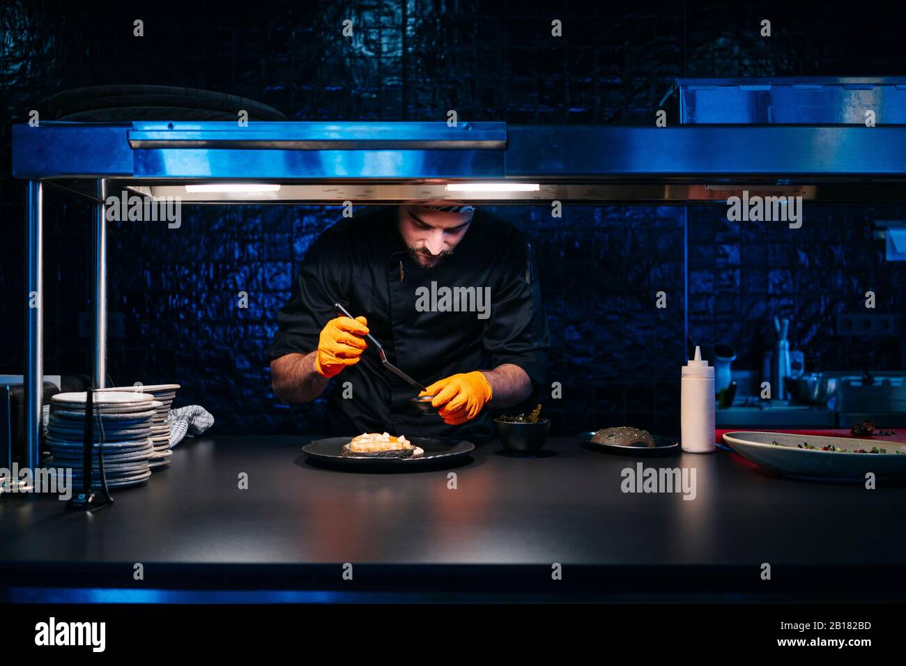 Küchenchef bereitet ein Gericht in der Restaurantküche zu Stockfoto