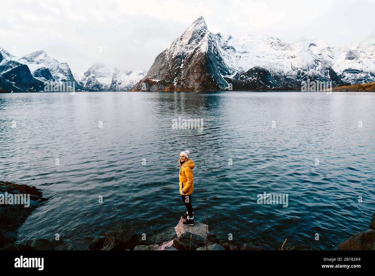 Fröhlicher Tourist, der auf einem Felsen in Hamnoy, Lofoten, Norwegen steht Stockfoto