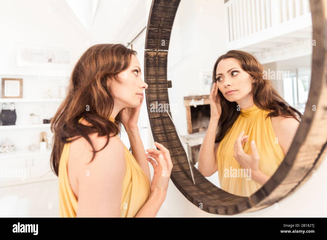 Brünette Frau tragen Abendkleid suchen im Spiegel Stockfoto