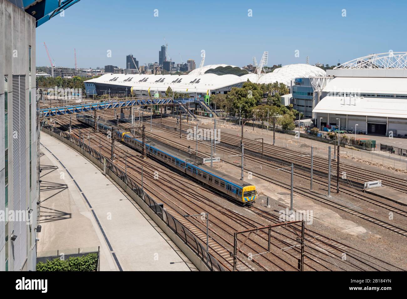 Ein einziger Zug fährt auf einer der vielen Linien, die zwischen dem MCG (links) und dem AAMI Fußballstadion in das Zentrum Melbournes einziehen Stockfoto