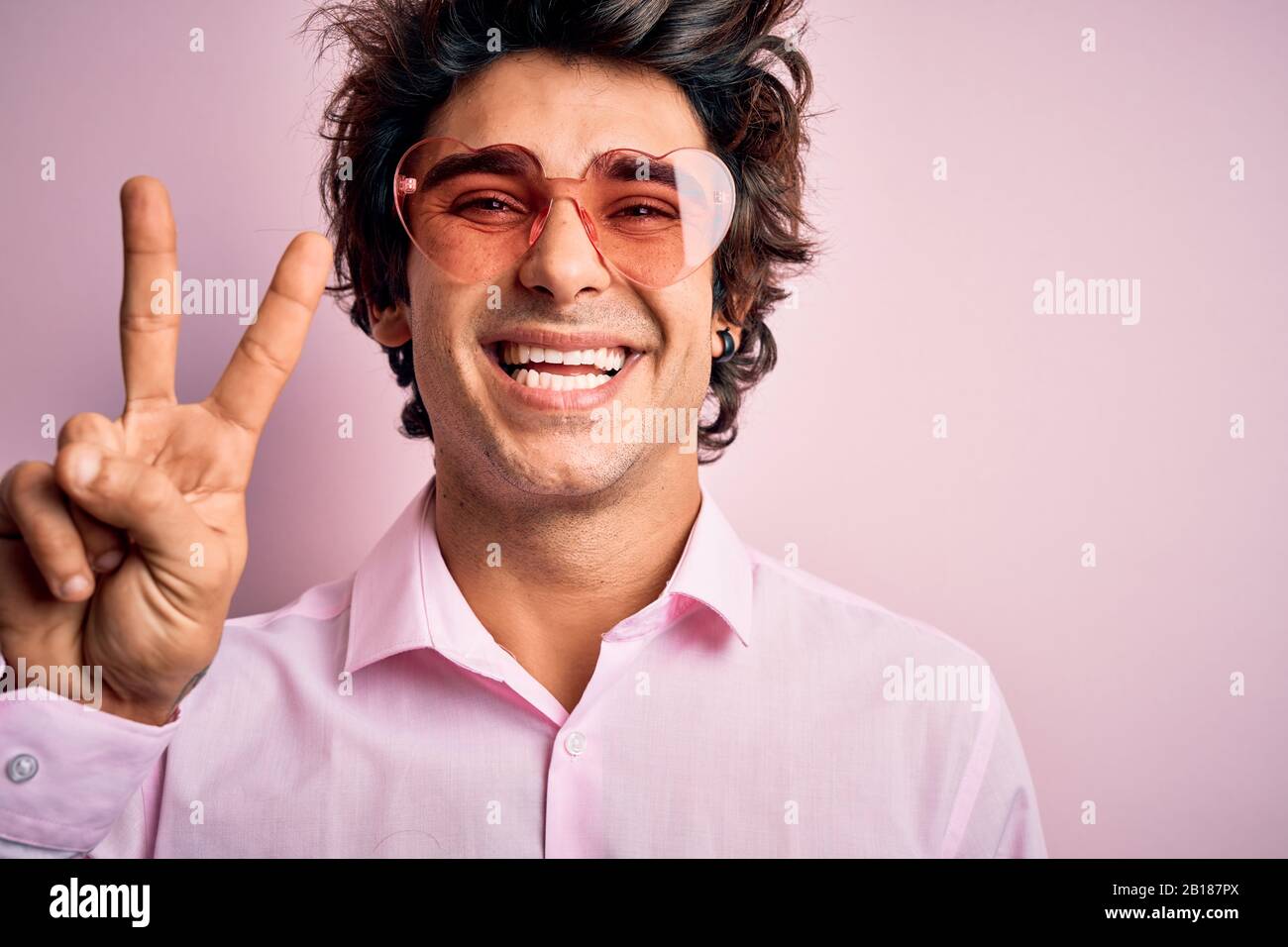 Junger gutaussehender Mann, der eine Brille mit Herzform über ...