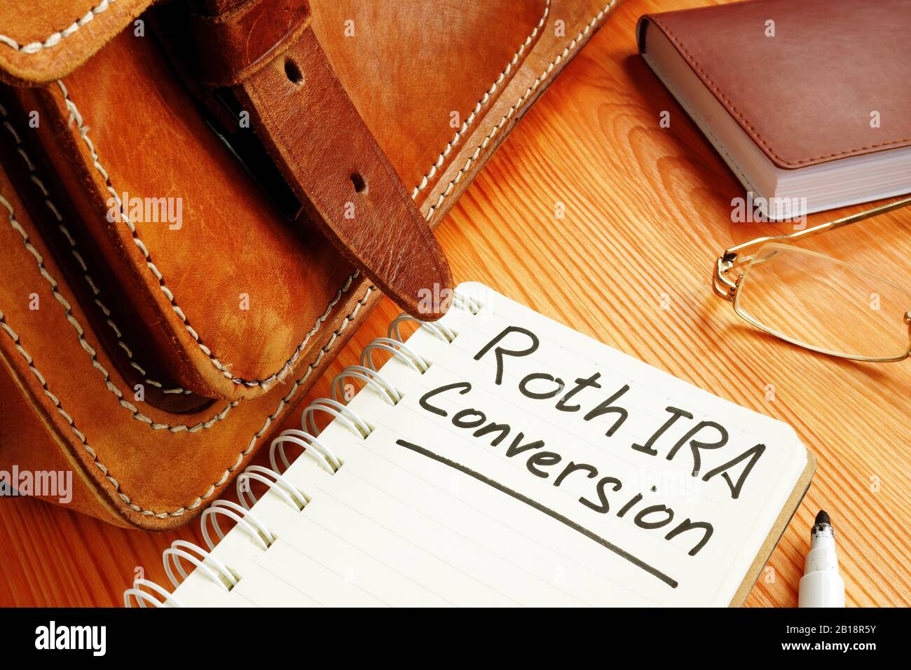 Roths ira-Konvertierungsnotiz in der Nähe von Retro-Aktentasche und Brille. Stockfoto Roths ira-Konvertierungsnotiz in der Nähe von Retro-Aktentasche und Brille. Stockfoto
